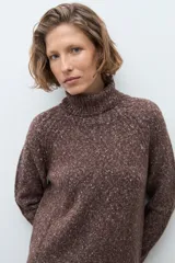 Polerón de cuello alto confeccionado en tejido buclé con textura jaspeada, de corte holgado y mangas largas con diseño raglán.