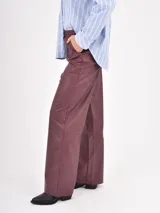 Pantalon de cuero sintetico color negro, de corte recto y holgado. Presenta cintura elastizada con cordon de ajuste y bolsillos laterales.
