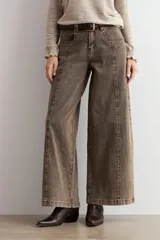Jean culotte de tiro alto y corte ancho, color marrón chocolate con efecto lavado. Presenta costuras verticales frontales, bolsillos laterales y cierre con botón y cremallera.
