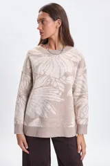 Buzo de punto con diseño jacquard de flores en tonos beige y crema, de corte holgado, cuello redondo y mangas largas con puños acanalados.