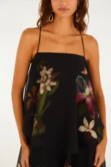 Vestido largo negro con tirantes finos, escote recto y diseño escalonado con capas superpuestas de volados con estampado floral.