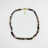 Collar compuesto por cuentas de turmalina natural en formato irregular y mix de colores, con cierre y cadena de extensión con baño de oro.