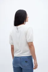 Remera color crudo con textura de tejido y escote en V, con mangas cortas abullonadas.