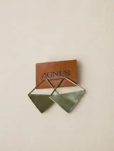 Aros colgantes con diseño geométrico en forma de triángulo, confeccionados en metal con acabado mate.