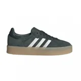 Championes Adidas modelo Sambae, de diseño urbano con capellada de gamuza en tono gris oscuro, icónicas tres tiras laterales en color blanco y suela de plataforma de goma en tono caramelo.