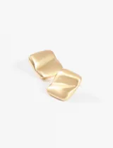 Aretes tipo botón de metal plateado con forma irregular y textura ondulada.