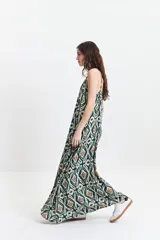 Vestido largo de silueta amplia con breteles finos y escote redondeado. Presenta un diseño fluido con frunces sutiles en el escote delantero y trasero, confeccionado en tela estampada con motivos geométricos.