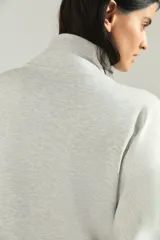 Campera deportiva de cuello alto con cierre frontal completo, mangas largas con puños elásticos y diseño holgado.