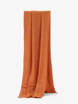 Bufanda lisa color naranja, con flecos pequeños en los extremos.