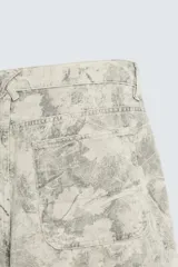 Bermuda relaxed fit de algodón, color beige con estampado abstracto en tonos grises. Cuenta con cinco bolsillos y cierre frontal de cremallera y botón.