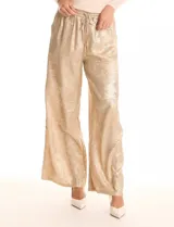 Pantalón wide leg de tela laminada metalizada color blanco, con pretina elástica y lazo de ajuste en la cintura. Cuenta con bolsillos laterales.