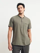 Camisa de manga corta con cuello mao y cierre frontal parcial con botones de coco. Confeccionada en una mezcla de lino y algodón.