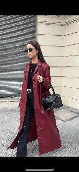 Cartera rígida negra con detalles en rojo y tachas plateadas. Tiene herrajes y cierre metálico plateado marca YKK, asa fina para llevar al hombro o en la mano y correa larga extra regulable. El interior es forrado, tiene un bolsillo con cierre enmarcado en cuero, y un segundo bolsillo plaqué.