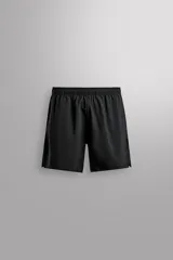 Pantalones deportivos cortos de tejido técnico ligero y elástico, con cintura elástica ajustable, bolsillos frontales y aberturas laterales en el bajo.