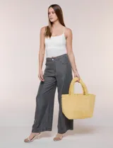 Cartera tipo shopper color amarillo de textura soft y flexible, con doble asa superior fija y compartimento principal amplio con botón metálico.