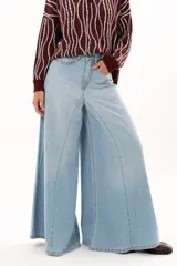 Jean de tiro alto con diseño de pierna extra ancha y caída fluida. Cuenta con bolsillos delanteros y traseros, cierre frontal con cremallera y botón metálico.