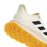 Championes Adidas para hockey sobre hierba, modelo Hockey Youngstar. Color crema con detalles en negro y suela color caramelo.