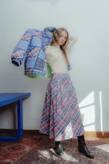 Campera puffer con estampado a cuadros en tonos azul, rojo, amarillo y blanco. Diseño capitoneado a mano y forro interior verde. Corte holgado. Ideal para usar con un look casual.