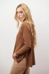 Sweater de tejido de punto color beige, con escote en V y mangas largas. Presenta un diseño básico y versátil de corte recto.