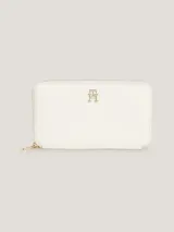 Billetera Tommy Hilfiger Iconic de poliuretano color blanco, con cierre de cremallera, insignia metálica del monograma TH y múltiples ranuras interiores para tarjetas, monedas y billetes.