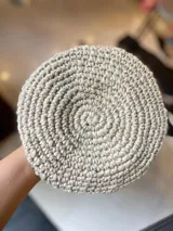 Boina tejida en crochet de lana merino con diseño circular en tonos celeste, blanco, gris y tostado.