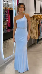 Vestido largo celeste con brillo, diseño de un solo hombro con tiras finas cruzadas en la espalda y detalle de cinto con pedrería en la cintura.