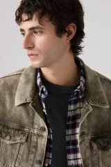 Campera tipo trucker de corte relajado, confeccionada en denim con un acabado desgastado en tono marrón claro. Presenta cierre frontal con botones metálicos, bolsillos con solapa en el pecho y costuras reforzadas.