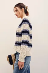 Sweater de punto con rayas horizontales en tonos beige y azul marino, manga larga y cuello redondo.