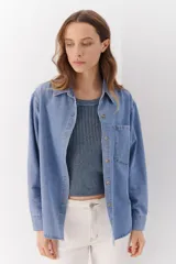 Camisa de jean celeste de manga larga con botones frontales y en los puños.