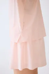 Musculosa deportiva rosada de corte estándar, confeccionada en tejido funcional DryMove que ayuda a absorber el sudor, con cuello redondo y aberturas laterales en el bajo.
