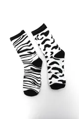 Pack de dos pares de medias crew en color blanco y negro con estampados de animal print, uno con diseño de cebra y otro con diseño de leopardo.