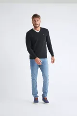 Sweater de tejido de punto color beige, con escote en V, mangas largas y puños y dobladillo acanalados. Presenta un pequeño logo bordado en el pecho.