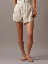 Short de pijama de corte regular confeccionado en popelina de algodón transpirable. Presenta cintura elástica con insignia de logotipo de Calvin Klein en la parte delantera y bolsillos laterales.