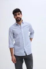 Camisa de manga larga fit semi slim color celeste, con cierre frontal de botones y cuello camisero clásico.