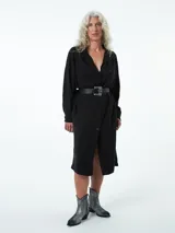 Túnica negra de manga larga con botones y bolsillos laterales.