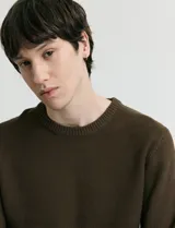 Sweater de punto con textura en color verde oscuro, de cuello redondo y manga larga.