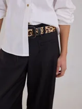 Pantalon de vestir negro de pierna ancha, con tiro medio-alto, bolsillos plaque delanteros y traseros, y pretina elastizada en la parte posterior.