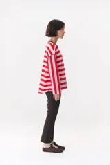 Remera de manga larga con corte oversized, color azul marino con cuello redondo en contraste color marrón. Presenta costuras decorativas a contratono hechas a mano en la zona de los hombros y logo bordado en el centro del pecho.