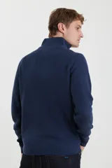 Sweater verde de punto inglés con cuello alto y cierre metálico frontal. Tiene mangas largas y terminaciones en punto canalé.