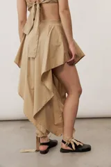 Pantalón estilo falda de color beige, con diseño amplio y fluido, tiro alto y pretina estructurada.