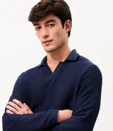 Remera de manga larga color marrón, confeccionada en tejido texturizado con cuello en V tipo polo. Presenta un diseño de calce confortable y acabado moderno.