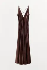 Vestido largo de tejido satinado con escote en pico pronunciado y tirantes finos cruzados en la espalda. Presenta un diseño con volumen en el bajo y forro interior a tono.