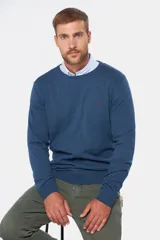 Buzo de punto color verde oscuro, con cuello redondo y mangas largas.