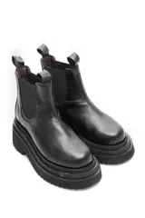 Borcego negro de cuero liso con elásticos laterales y suela de goma.