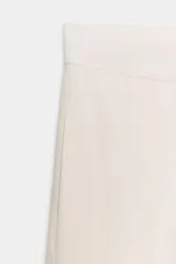 Pantalón cropped de tiro alto confeccionado en lino color crudo, con bolsillos laterales ocultos y pliegues frontales.