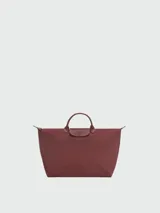 Bolso de viaje grande Longchamp modelo Le Pliage, color negro, confeccionado en nylon con detalles de cuero en las asas y solapa frontal con cierre de botón a presión.