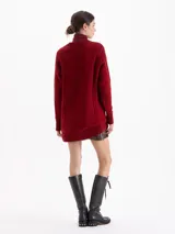 Sweater de punto color rojo con diseño de trenzas verticales y textura estructurada. Presenta cuello redondo, mangas largas y un corte holgado con terminaciones acanaladas.