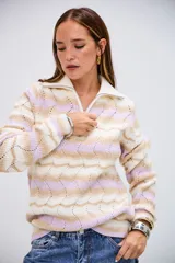 Sweater de punto con diseño de ondas en colores blanco, beige y lila. Presenta cuello polo con cierre de cremallera y mangas largas.