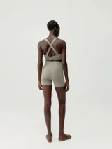 Short deportivo negro de tejido Shape_Tech, con tecnología performance, compacto y ligero. Diseño sin cinturilla, con costuras termoselladas y cinta reflectante decorativa en los laterales.