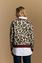 Sweater de tejido jacquard con estampado animal print, de silueta relajada y manga larga. Presenta cuello redondo y bordes en contraste de color bordó.